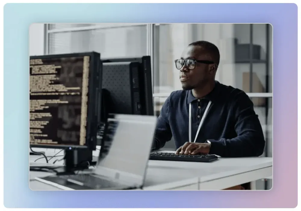 Homme devant des écrans affichant du code informatique