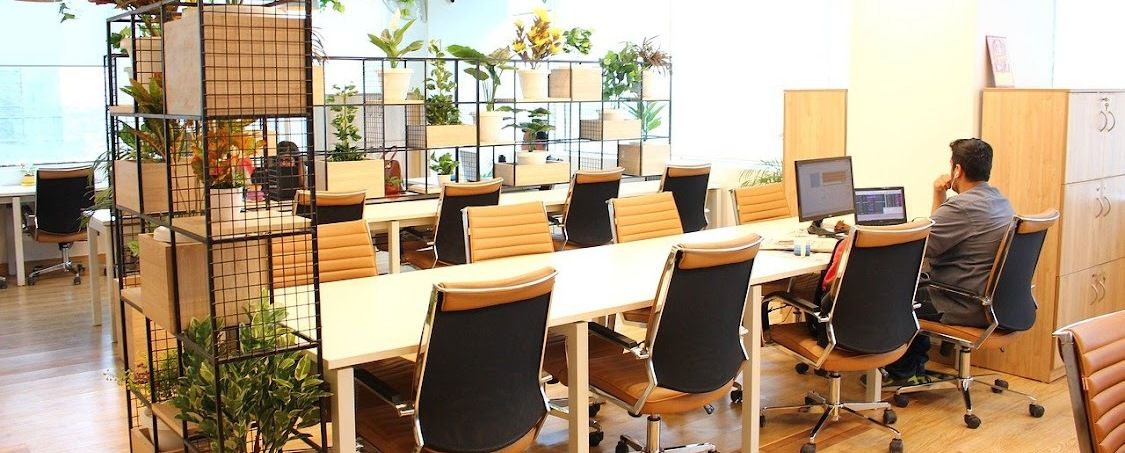 Open space avec des bureaux partagés et des plantes, pour le travail hybride